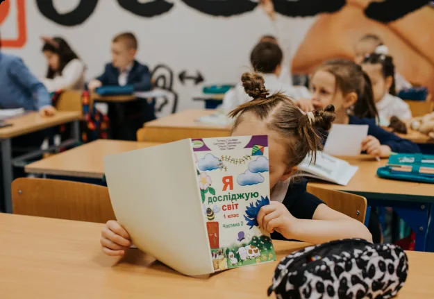 Першокласники «Першої української школи» на занятті з підручником НУШ